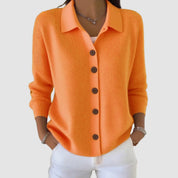 Dames gebreid vest in oranje, kraag en knoopsluiting, lange mouwen, donkere knopen.